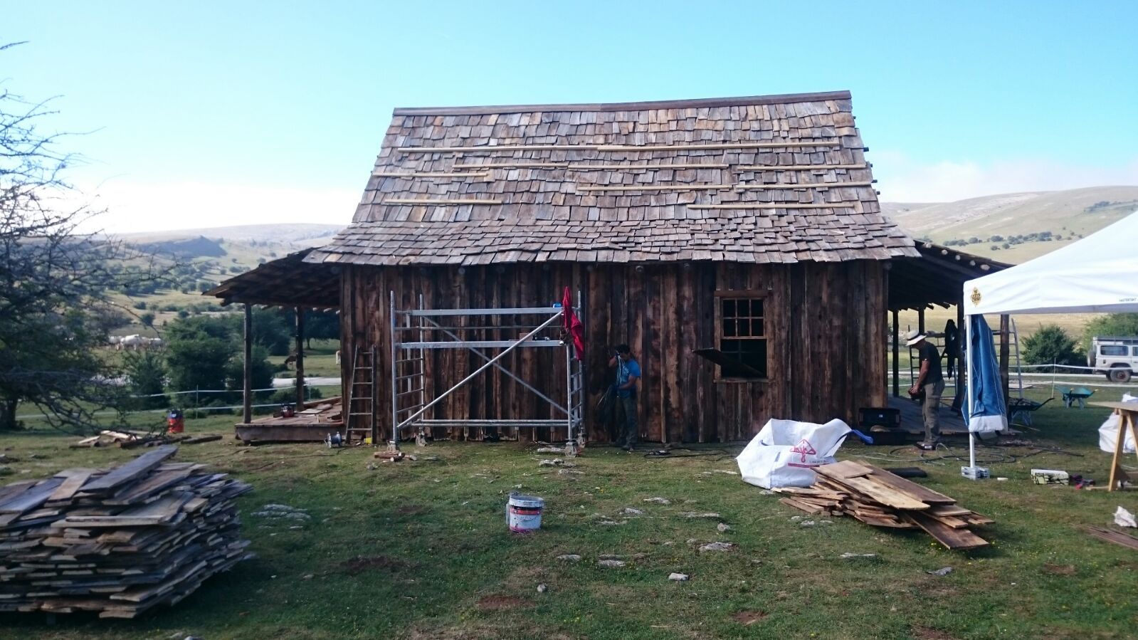 Se está restaurando una casa de madera con techo de paja.