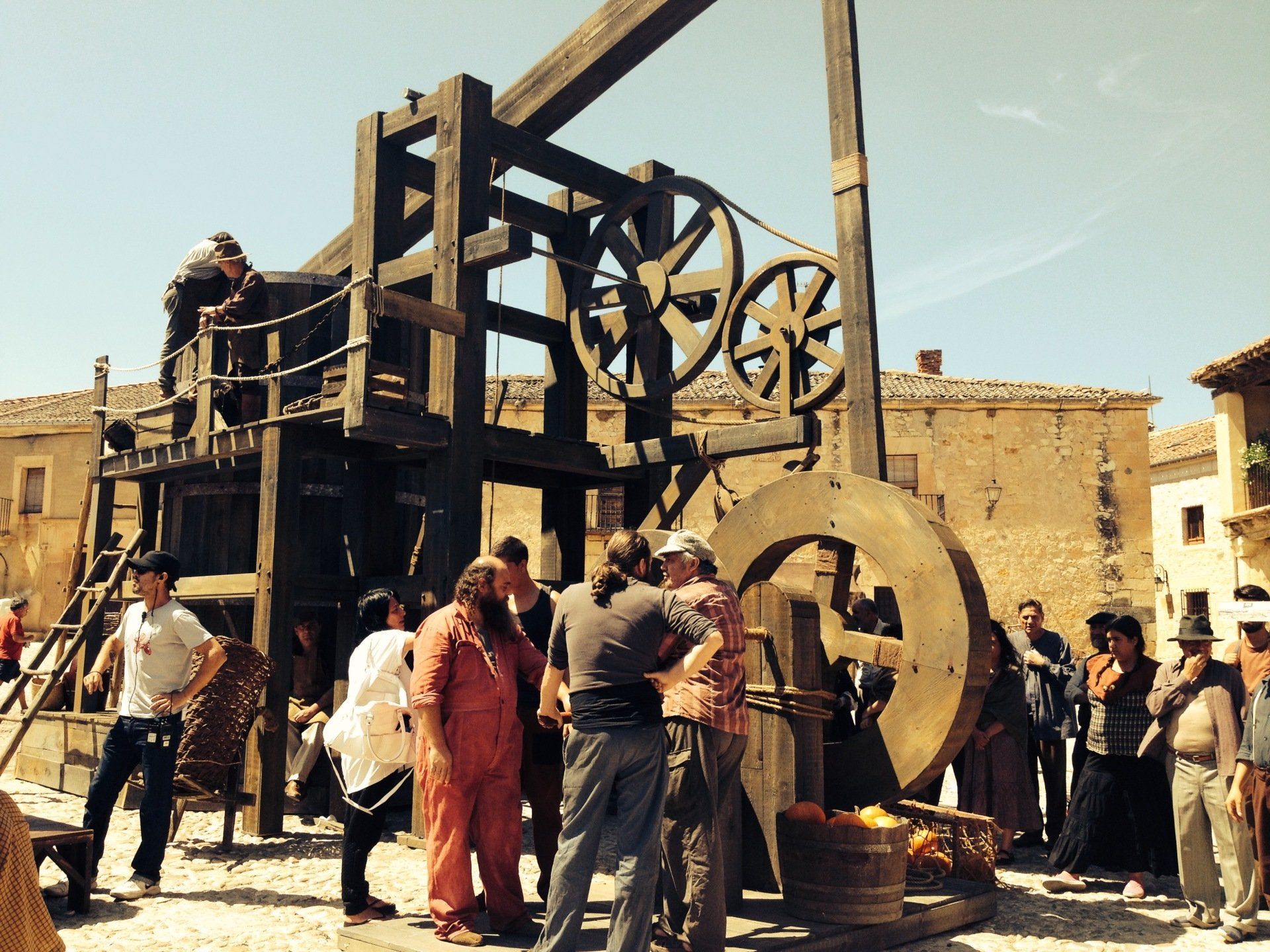 Un grupo de personas está de pie alrededor de una gran estructura de madera.