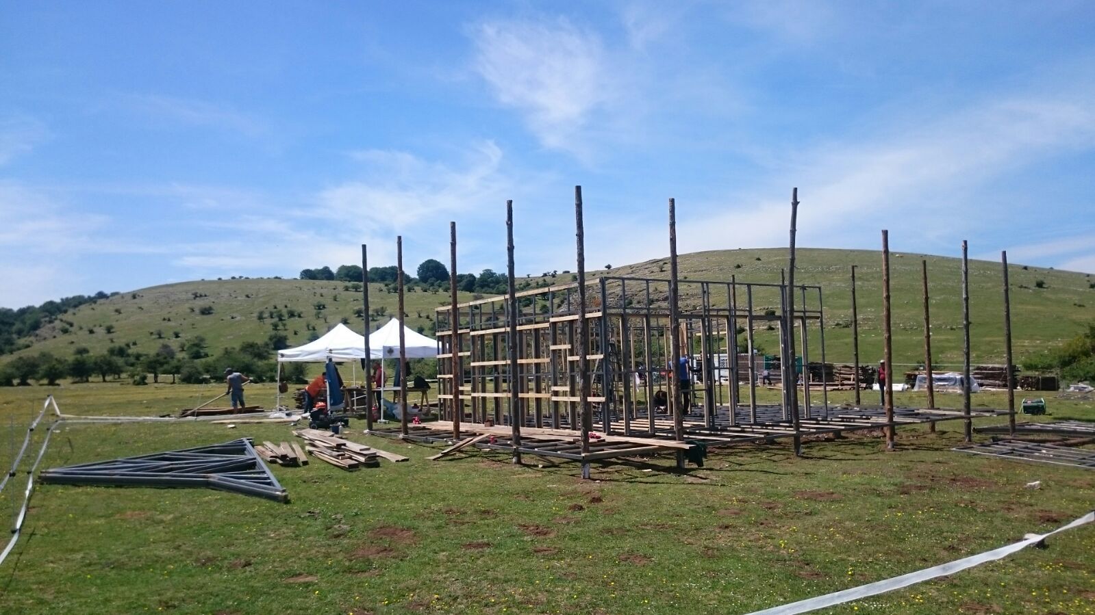 Se está construyendo una gran estructura de madera en un campo de hierba.