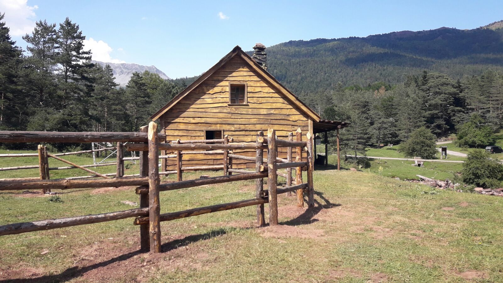 Una pequeña cabaña de madera en medio de un campo de hierba.
