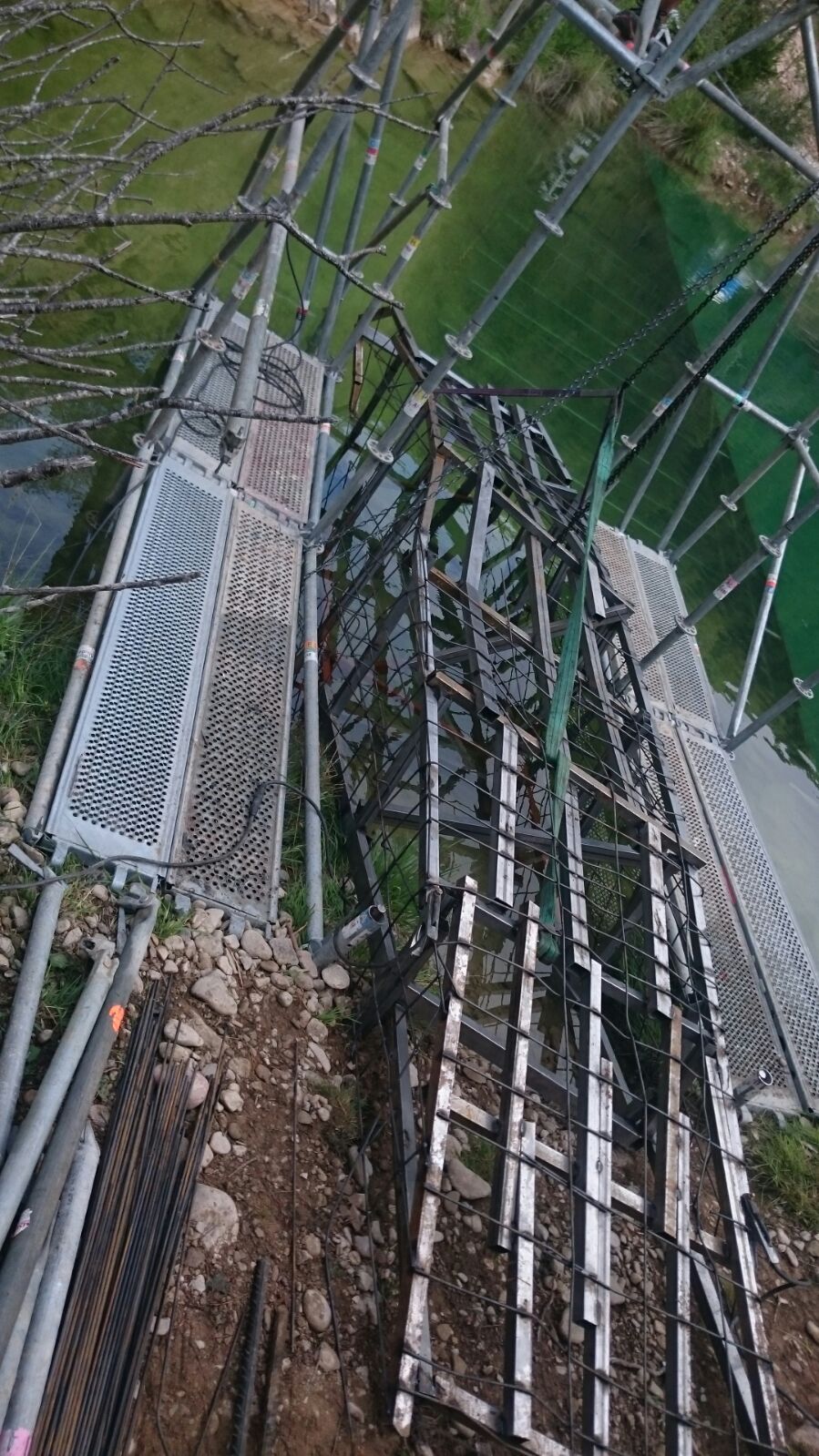 Una escalera está colocada encima de una estructura de metal al lado de un cuerpo de agua.