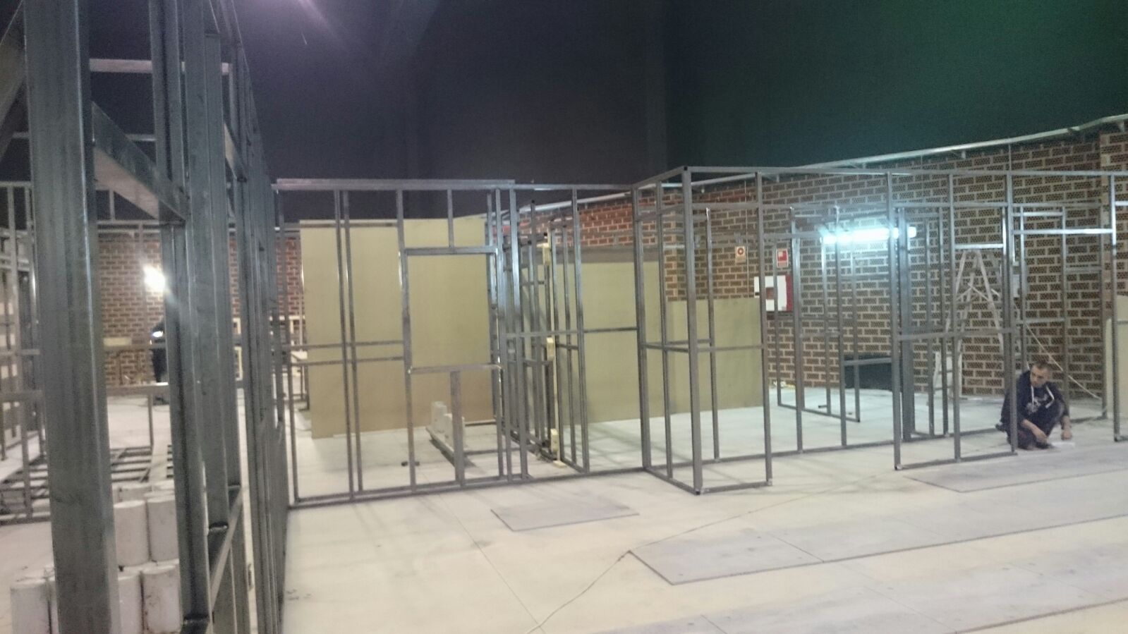 Un hombre está sentado en el suelo en un edificio en construcción.