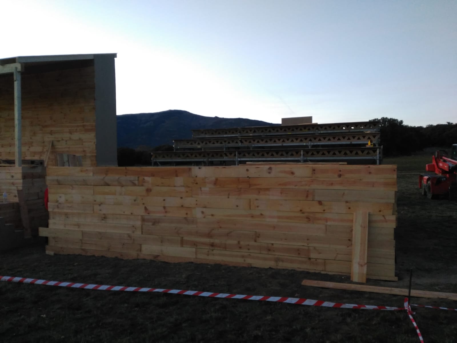Se está construyendo un gran muro de madera en un campo.
