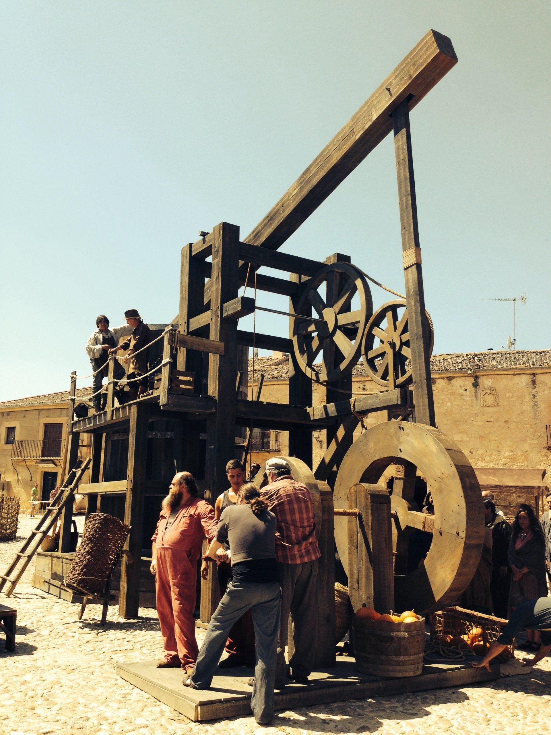 Un grupo de personas de pie alrededor de una gran estructura de madera.