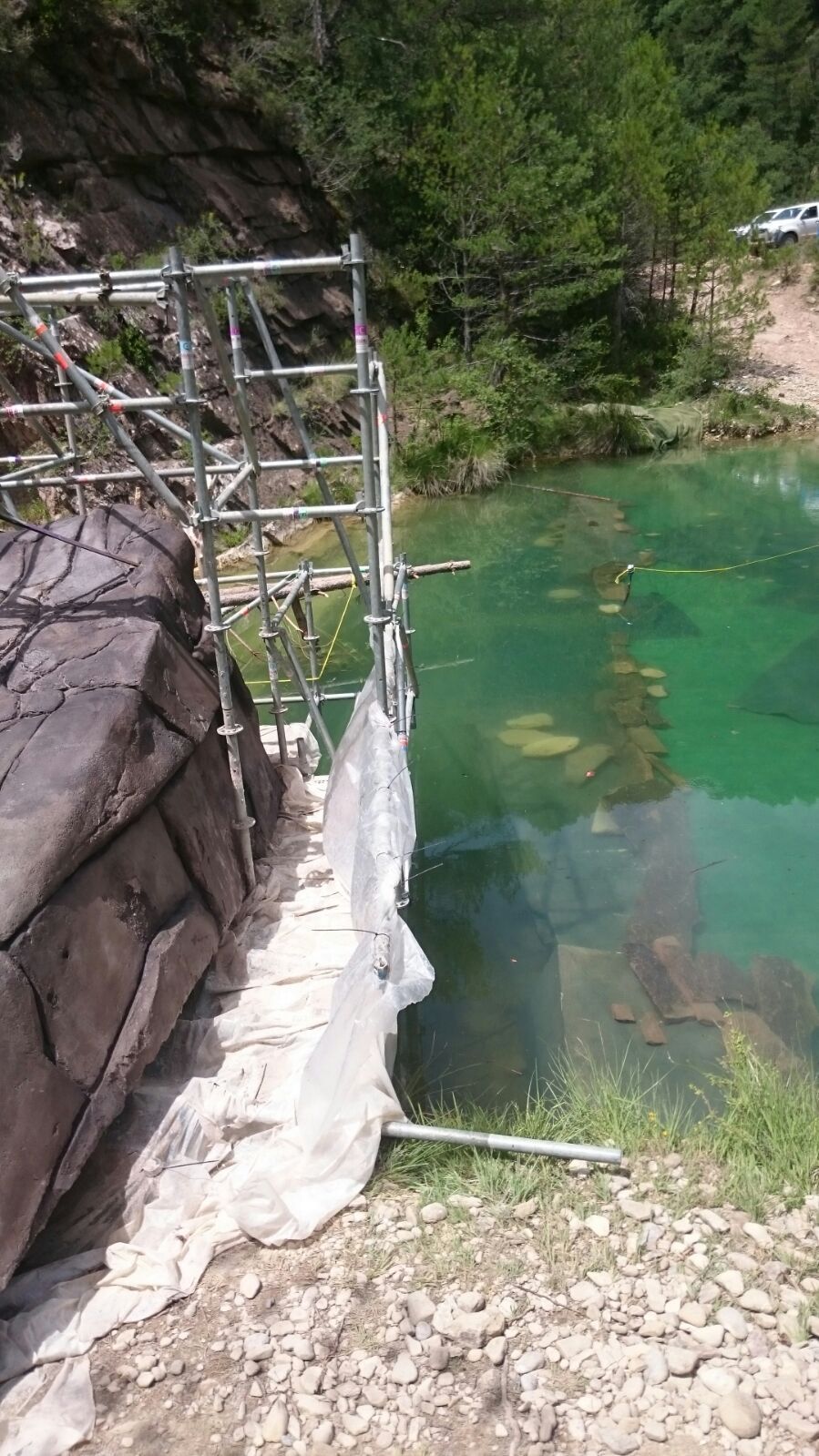 Se está construyendo un puente sobre un lago en las montañas.