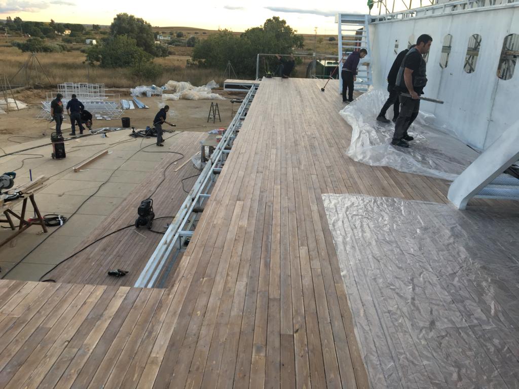 Un grupo de personas está trabajando en una terraza de madera.