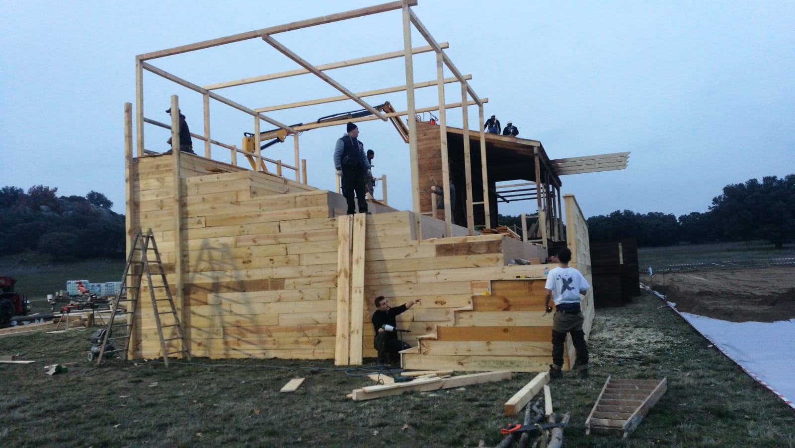 Un hombre que lleva una camiseta que dice 'x' está trabajando en una estructura de madera.
