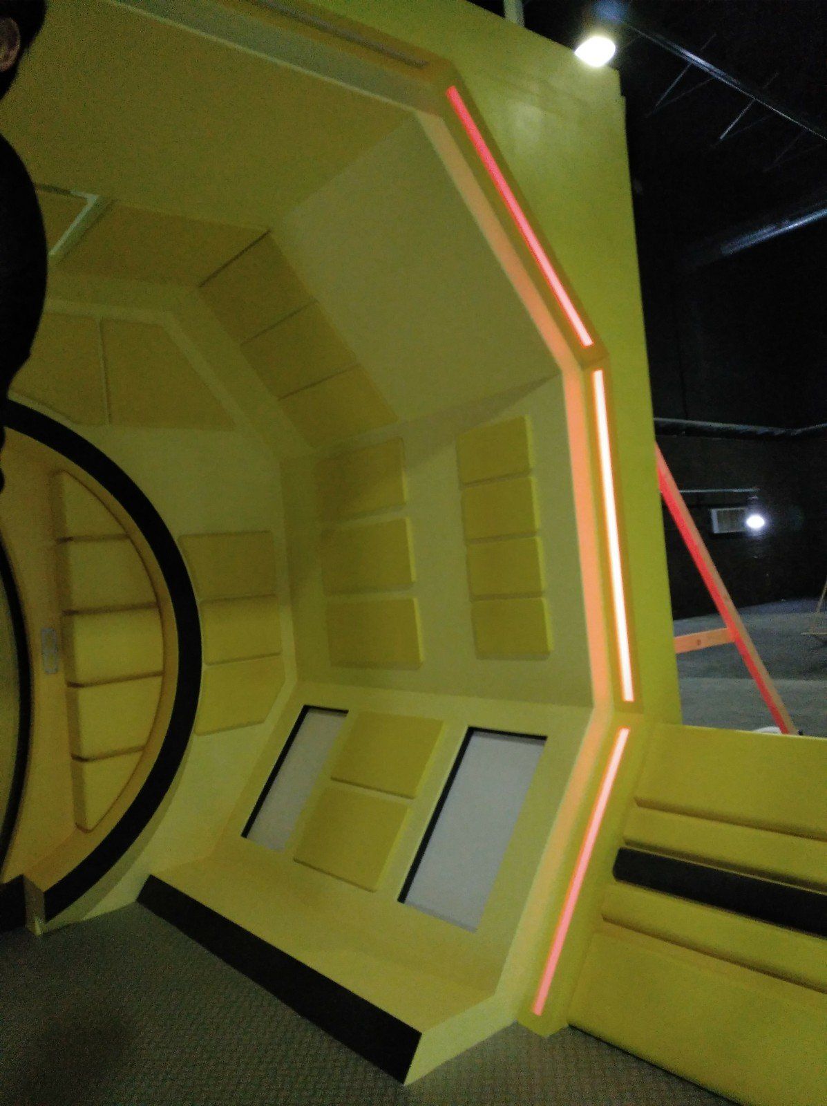 Una habitación amarilla con una luz roja en la esquina