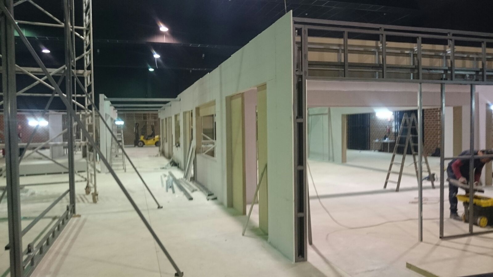 Se está construyendo un edificio por la noche con muchos andamios.