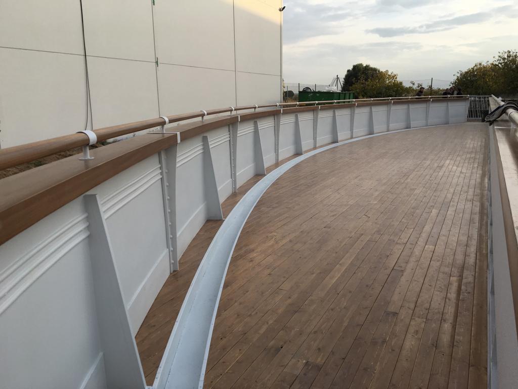 Un puente con cubierta de madera y barandilla blanca.