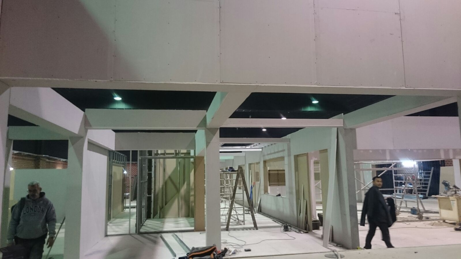 Un hombre está de pie en un edificio en construcción por la noche.