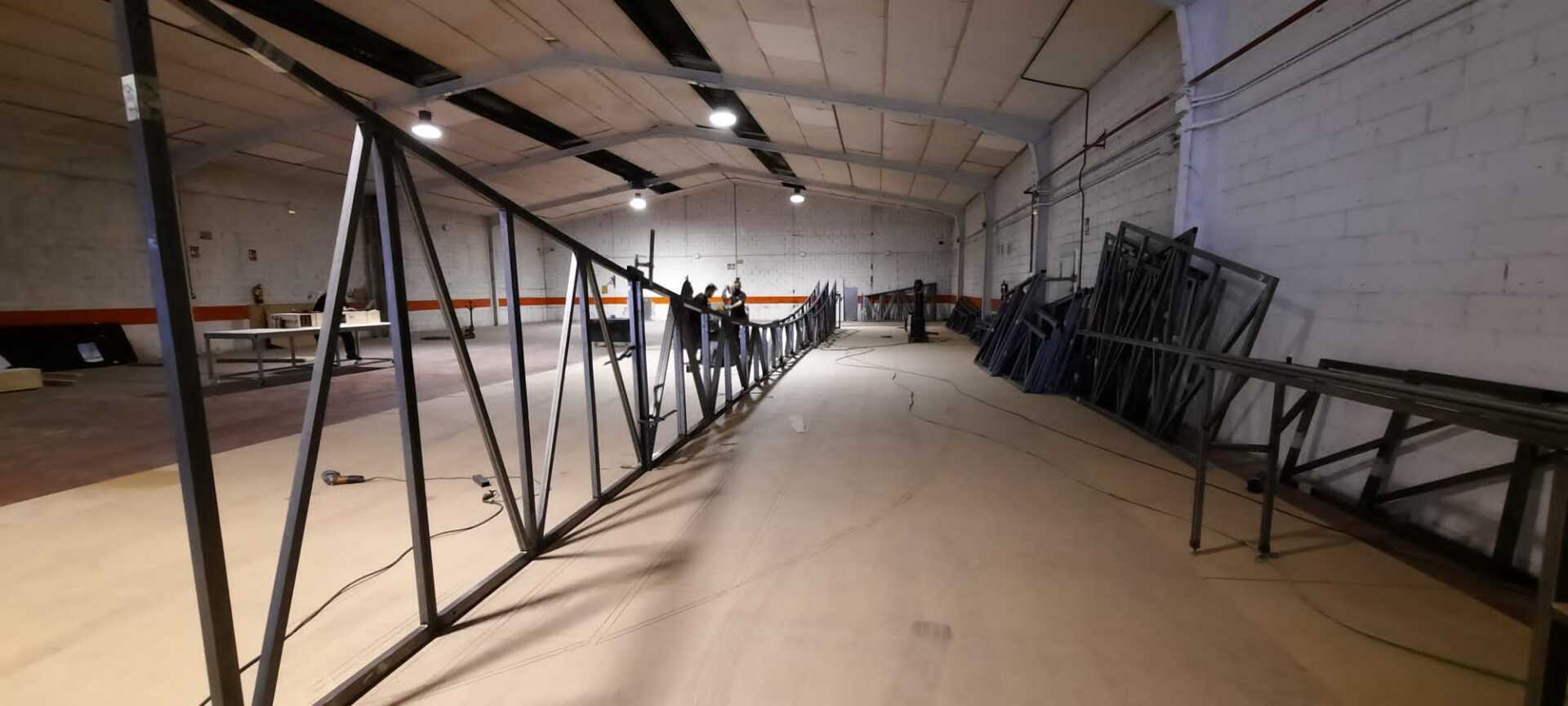 Un gran almacén vacío con muchas piezas de metal en el suelo.