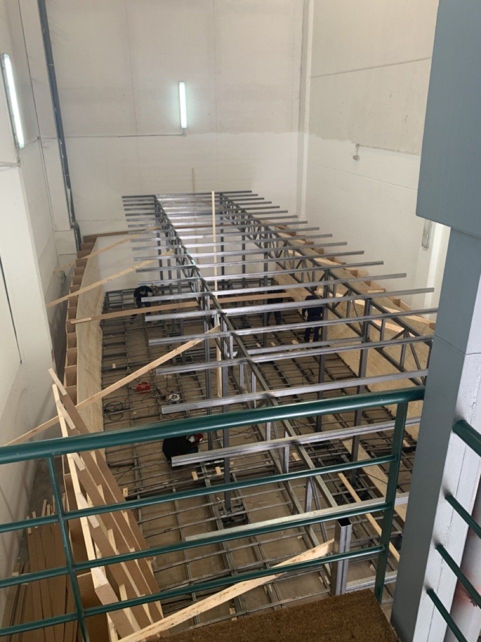 Una vista aérea de un edificio en construcción con una barandilla verde.