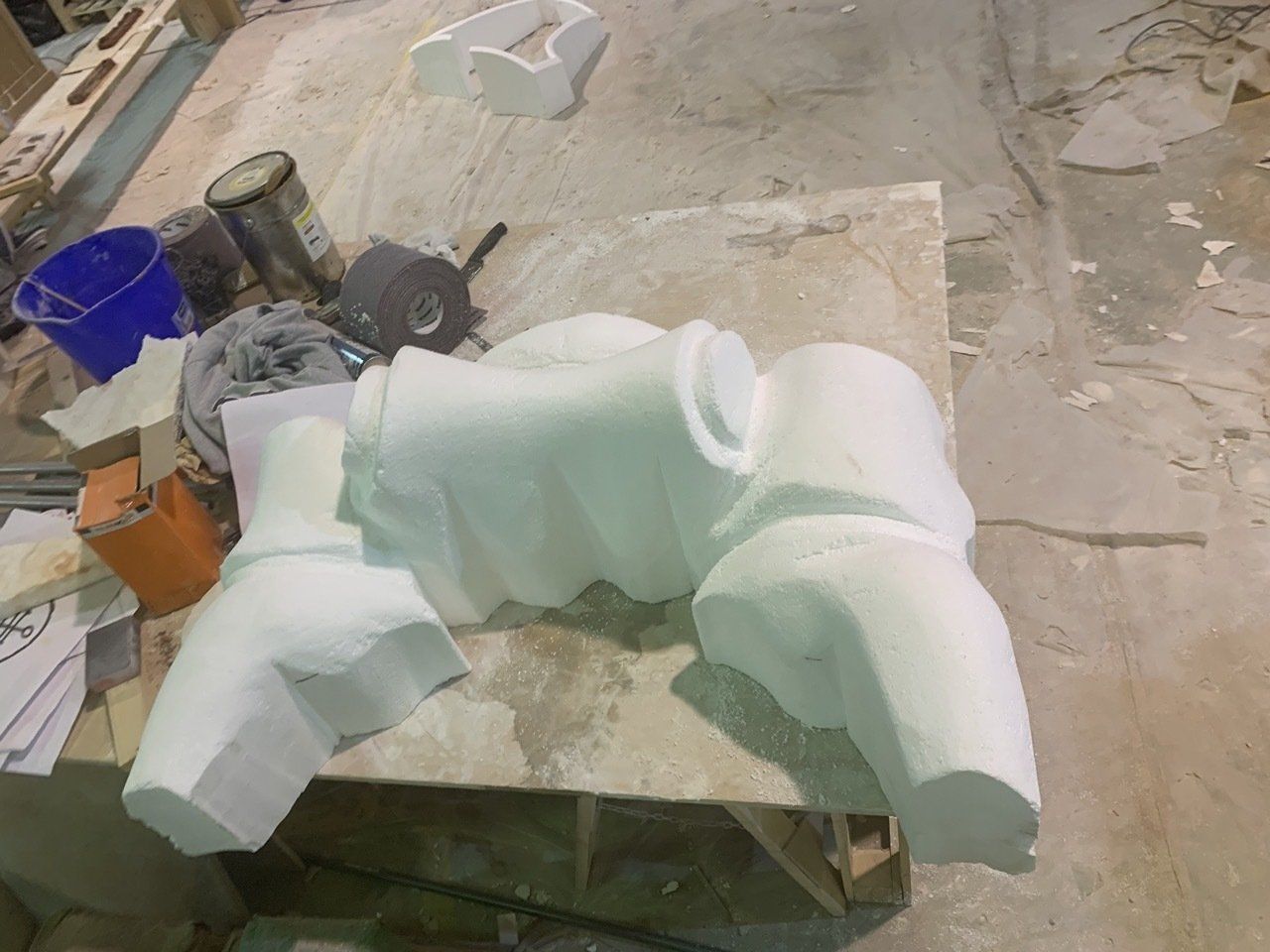 Una escultura blanca está sentada encima de una mesa de madera.