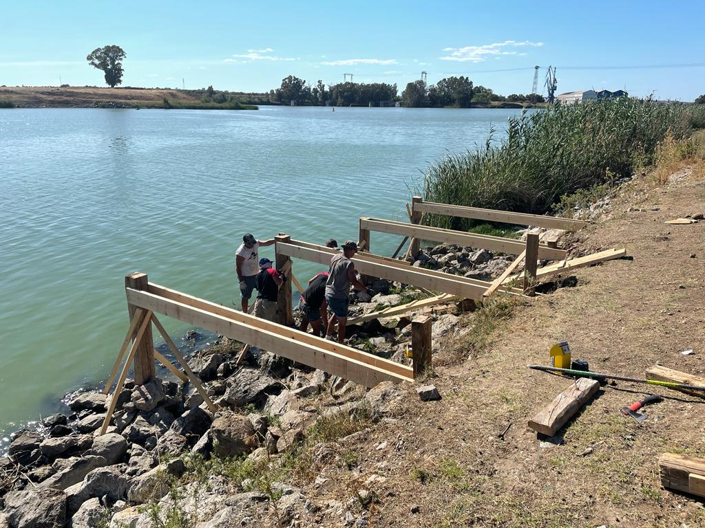 Un grupo de personas está de pie en la orilla de un lago.