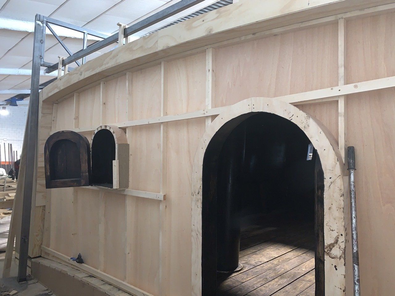 Se está construyendo un edificio de madera con ventanas arqueadas.