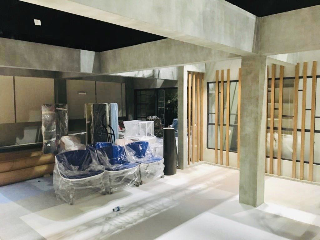 Una habitación grande con muchos muebles envueltos en plástico.