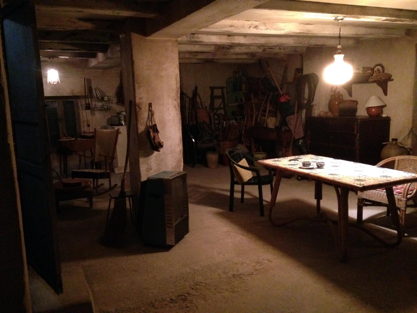 Una habitación oscura con una mesa y sillas.