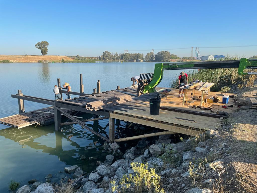 Se está construyendo un muelle de madera al lado de un lago.