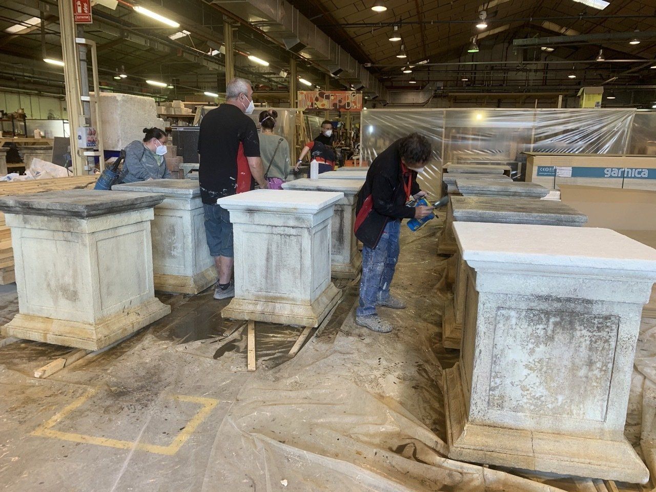 Un grupo de personas está trabajando en columnas en una fábrica.