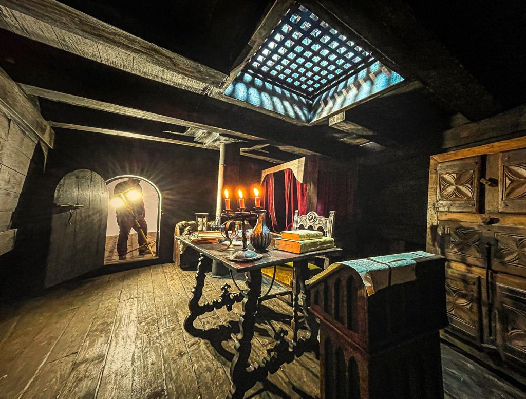 Una habitación oscura con una mesa y sillas.