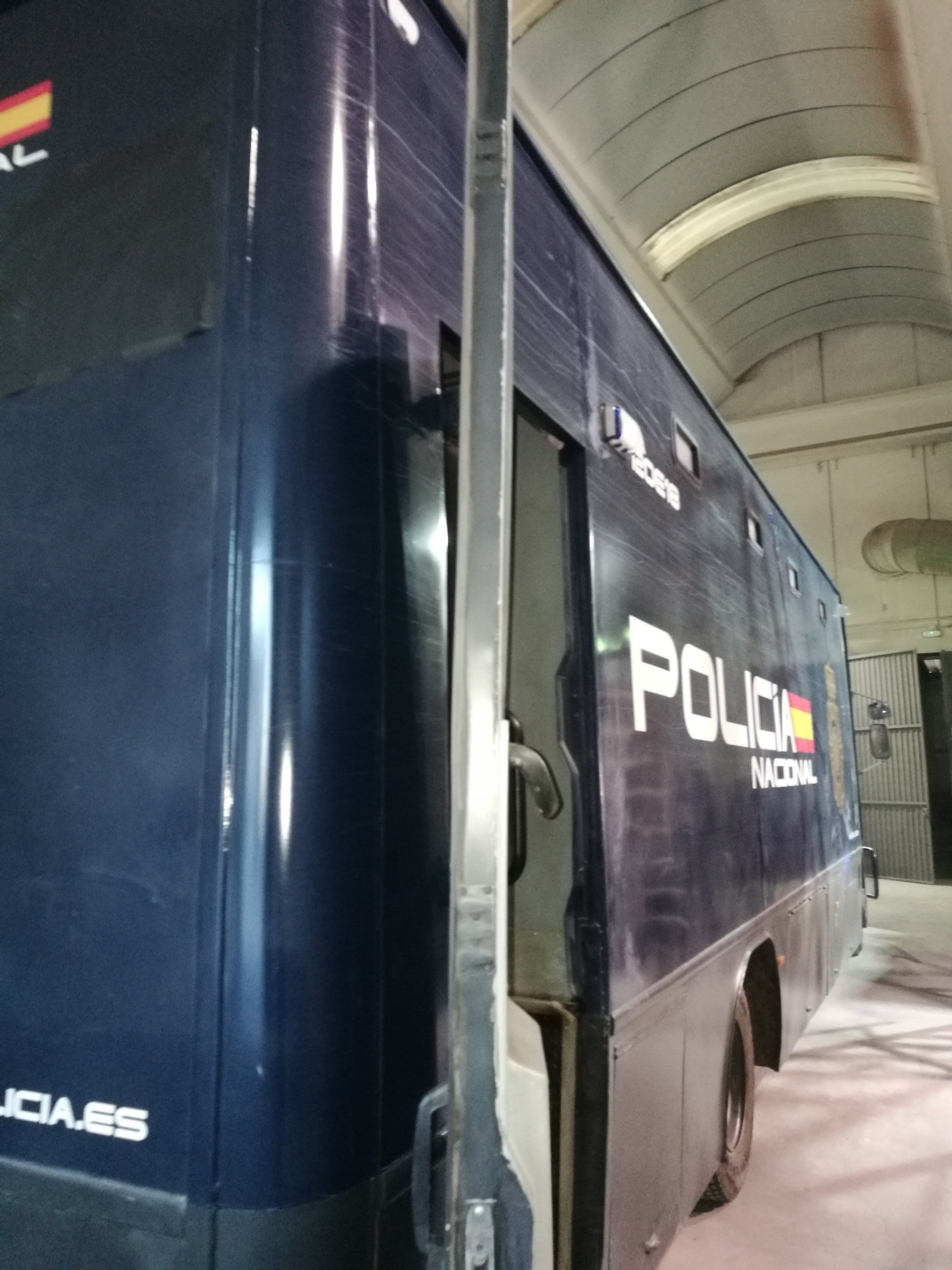 Un autobús azul con la palabra policía en el costado.