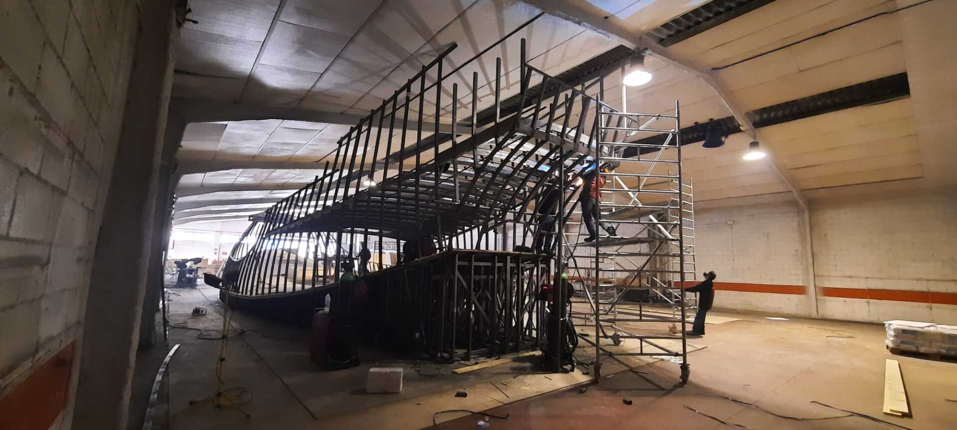 Se está construyendo una gran estructura metálica en un almacén.