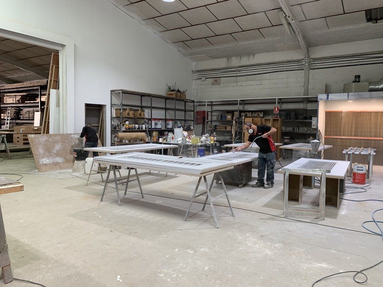 Un hombre está trabajando en una mesa en un taller.