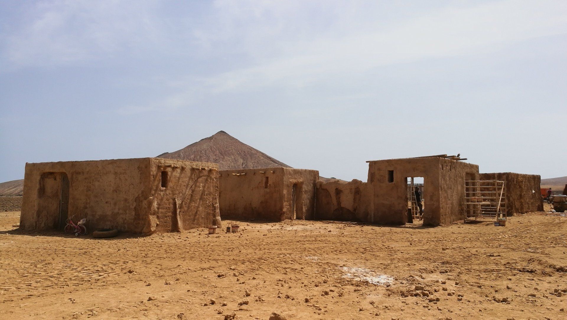 Un grupo de edificios en el desierto con una montaña al fondo.