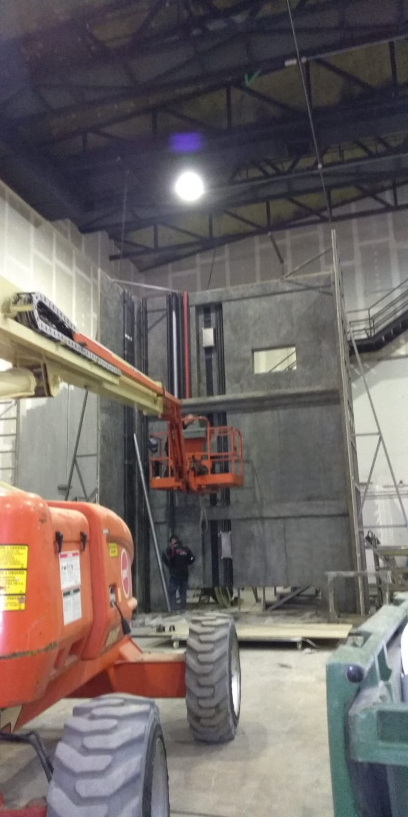 Un gran ascensor naranja está estacionado en un gran almacén.