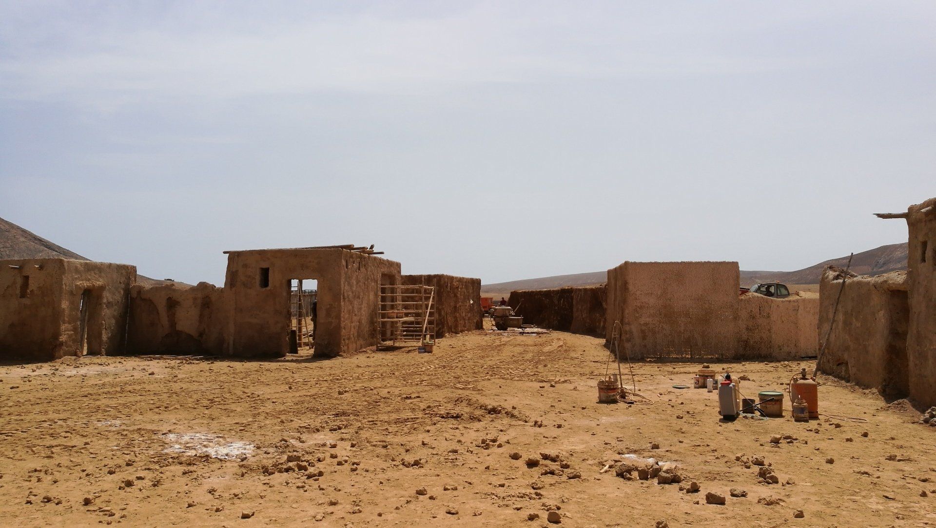 Un paisaje desértico con algunos edificios en la distancia.
