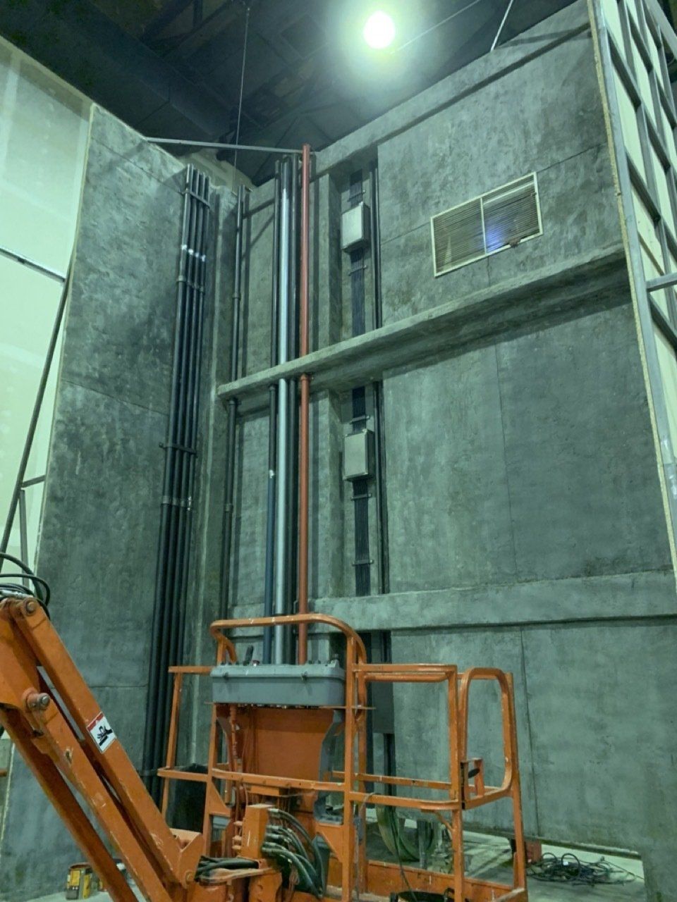 Un ascensor naranja está parado frente a un gran edificio.