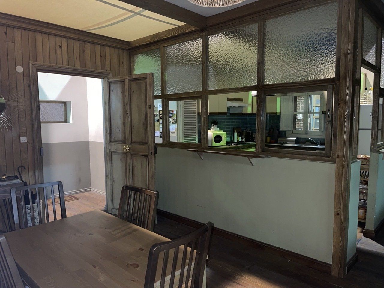 Un comedor con una mesa y sillas y una cocina al fondo.