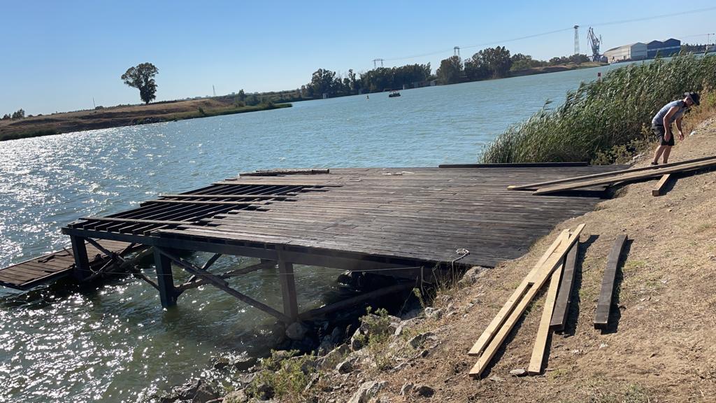 Se está construyendo un muelle de madera al lado de un cuerpo de agua.