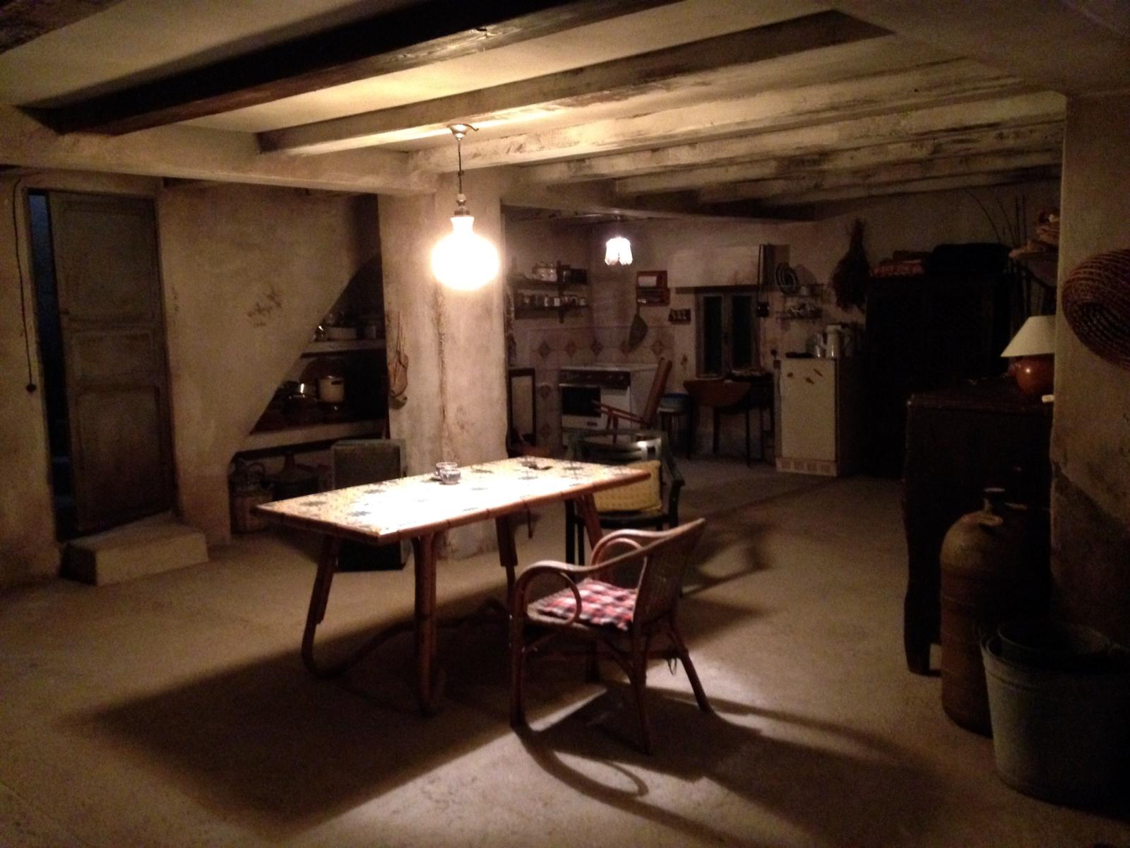 Una habitación oscura con una mesa y sillas.