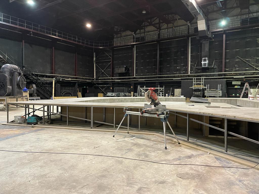 Un hombre está trabajando en un escenario en un edificio grande.