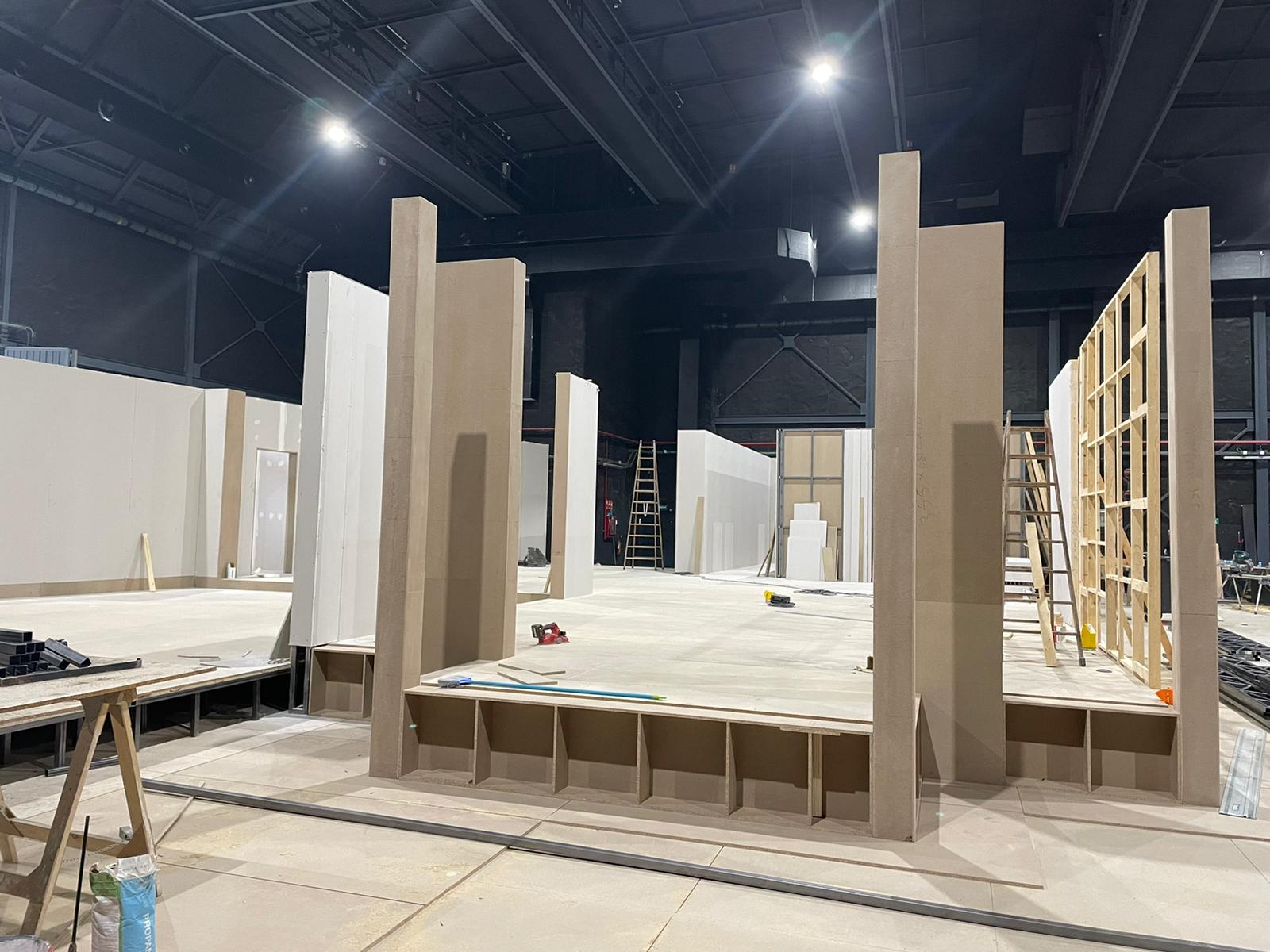 Una habitación grande con muchas paredes de cartón y una escalera.