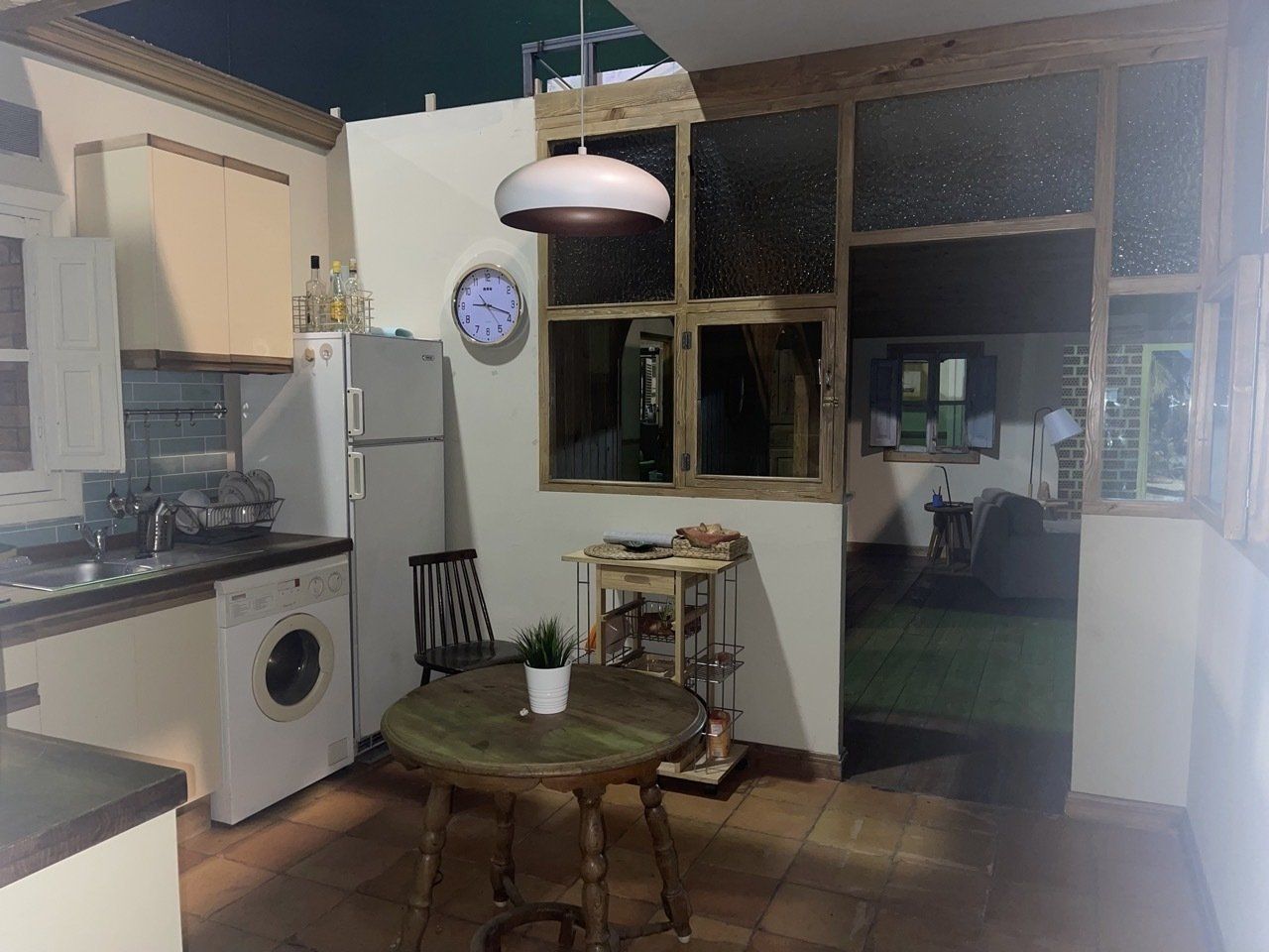 Una cocina con una mesa y sillas y un reloj en la pared.