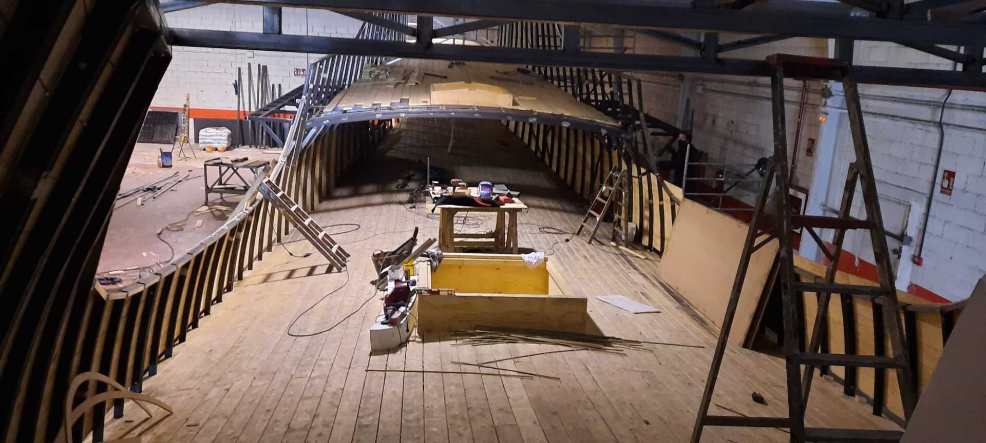 El interior de un edificio con piso de madera y una escalera.