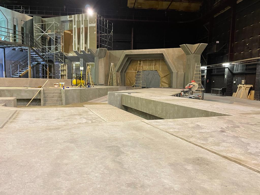 Un gran edificio vacío con piso de concreto y escaleras.