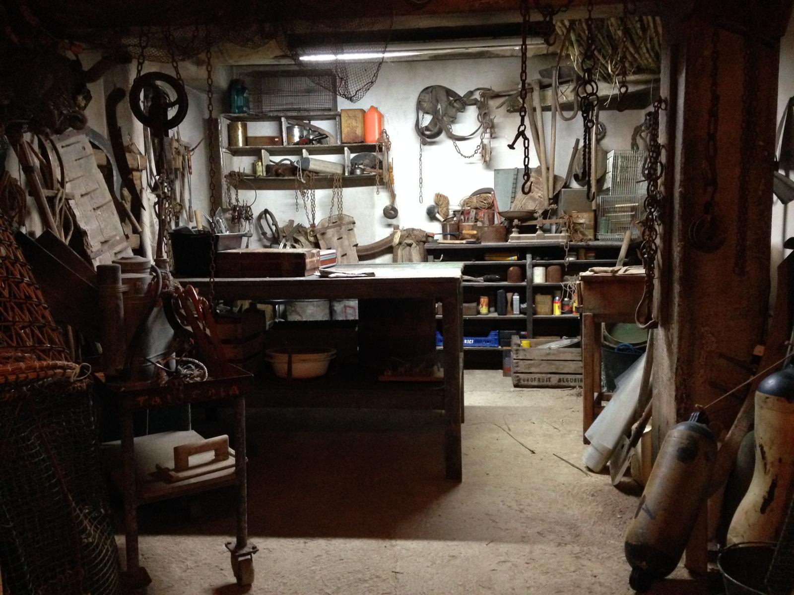 Una habitación muy desordenada con una mesa en el medio.