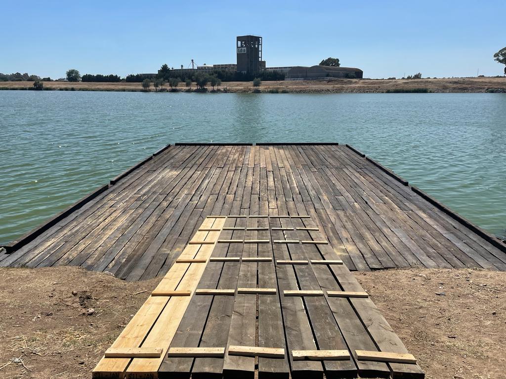 Un muelle de madera que conduce a un gran cuerpo de agua.