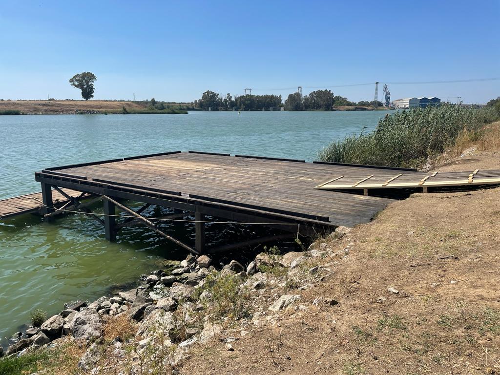 Un muelle de madera está sentado en la orilla de un lago.