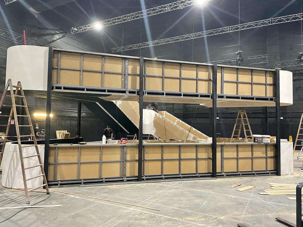 Se está construyendo una gran estructura de madera en una habitación grande.