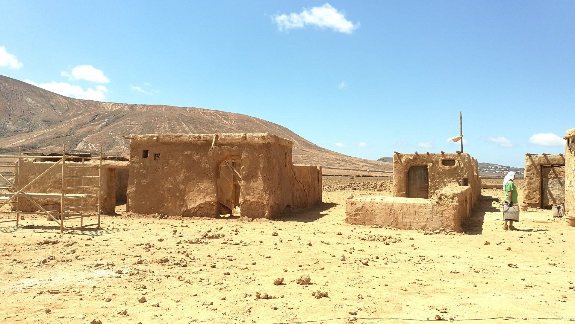 Un grupo de edificios en el desierto con montañas al fondo.