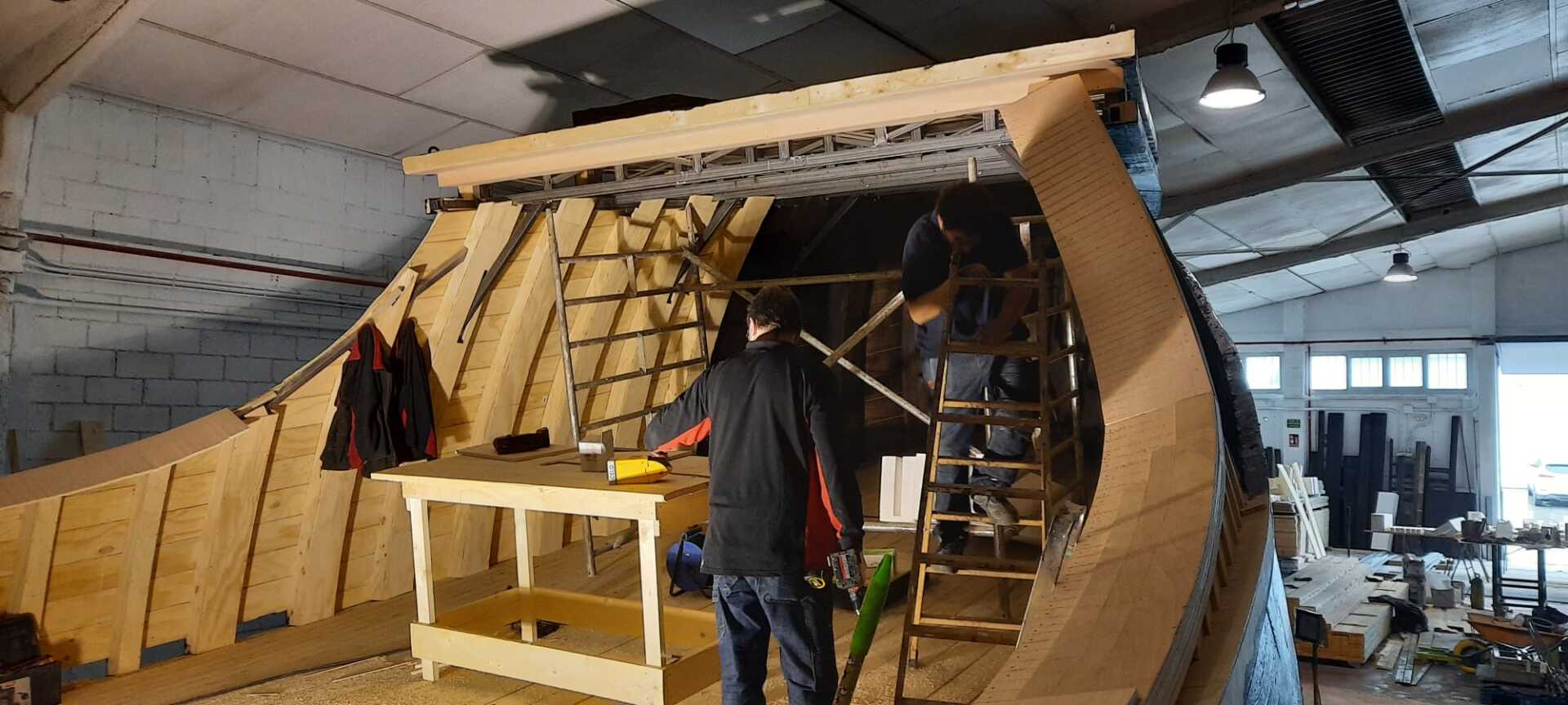Un grupo de personas está trabajando en una estructura de madera en un edificio.