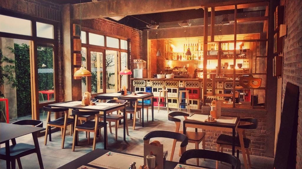 Hay muchas mesas y sillas en el restaurante.