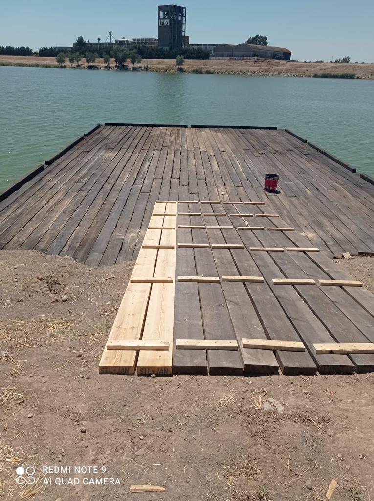 Se está construyendo un muelle de madera al lado de un cuerpo de agua.