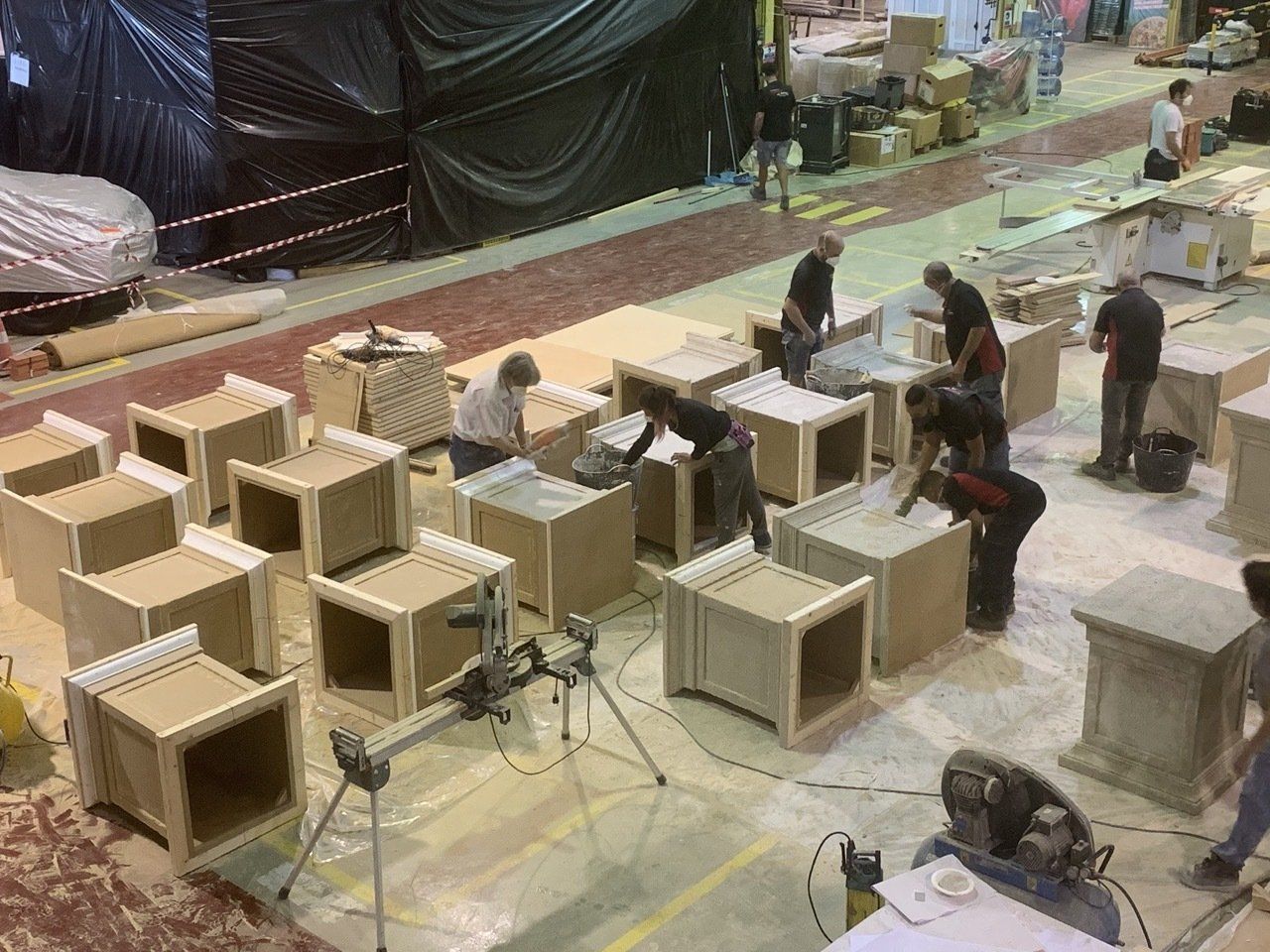 Un grupo de personas está trabajando en cajas de madera en una fábrica.