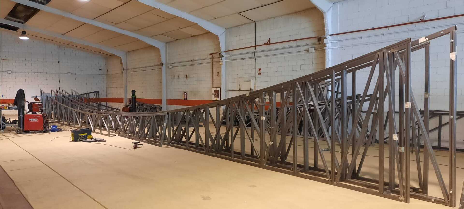 Se está construyendo una gran estructura metálica en un almacén.